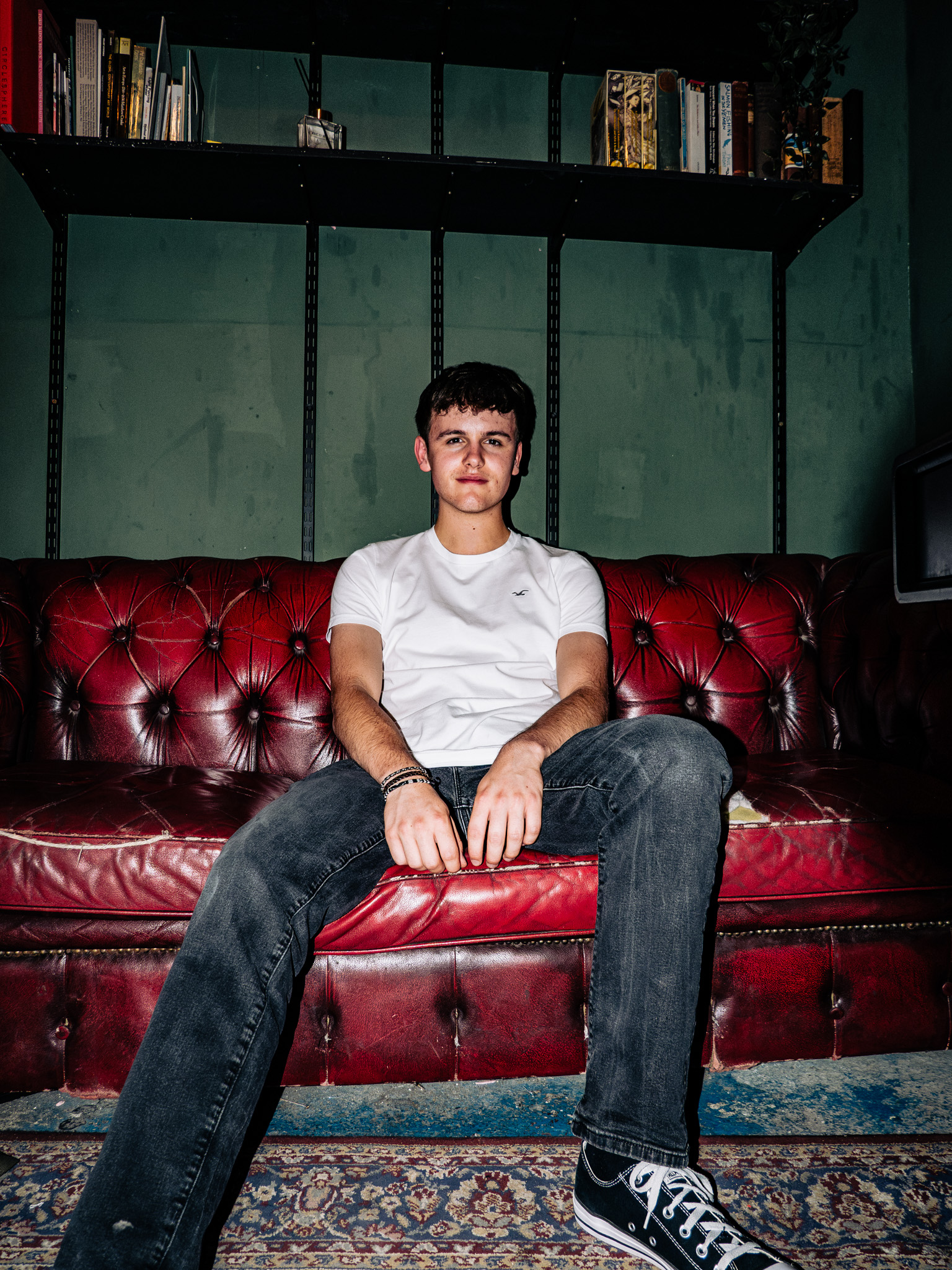 Austin sitting on a red leather sofa